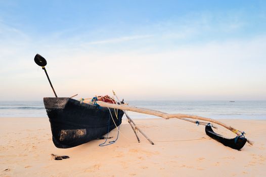 Old fishing boat on the sandy beach in Goa