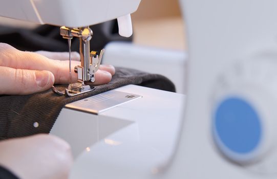  woman hands sewing on the stitching machine