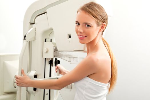 A young woman having taking a mammogram, looking at the camera