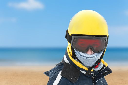 Girl in skiing outfit against summer beach