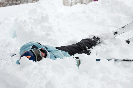 Female skier fallen into deep snow 