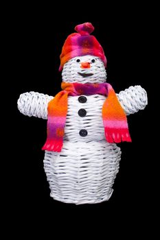 Knitted paper snowman with hat and scarf. Isolated on black.