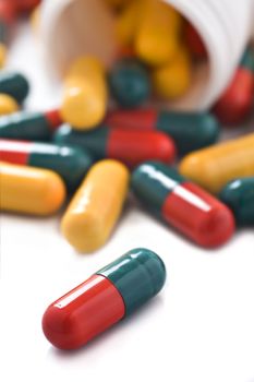 Yellow red and green capsules with bottle