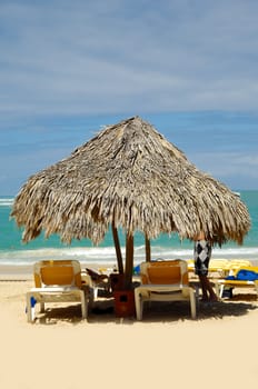 Parasol made out of palm leafs on exotic beach.