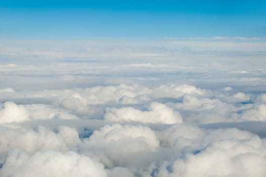 White clouds taken form above while flying in a plane.