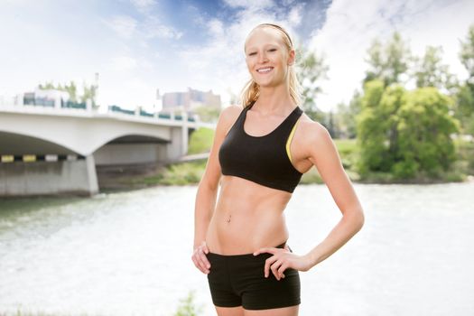 Portrait of beautiful woman smiling and posing against bridge