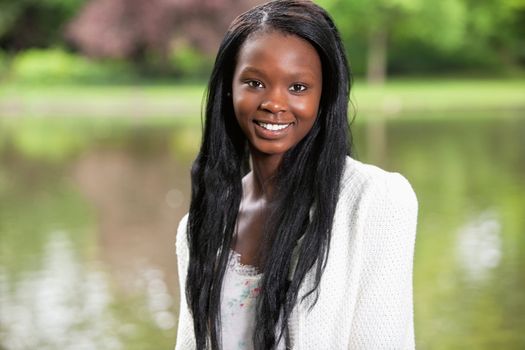 Portrait of young African American woman smiling against blurred background