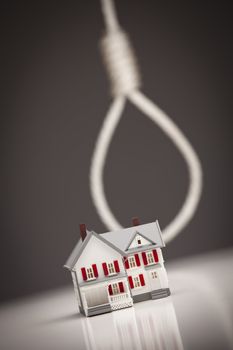 Small House with Hangman's Noose Behind on Grey Background.