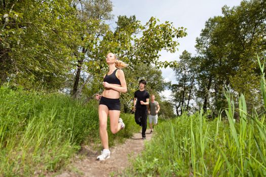 Health conscious people running on forest trail