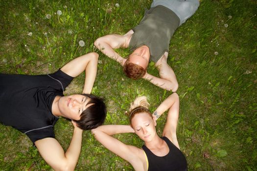 Close-up of friends resting on grass outdoors