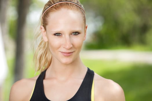 Close-up portrait of smiling young woman against blur background