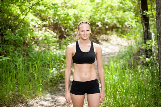 Portrait of a beautiful woman standing in sportswear against blur background