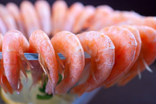 tasty shrimps with lemon and greens closeup