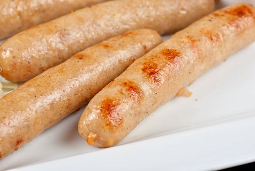 Grilled sausages with cabbage, greens and tomato sauce on white plate