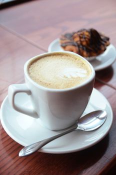 Chocolate muffins with and coffee cup on orange table