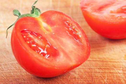 Closeup view of single tomato on a wood board