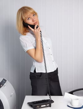 A young woman calls by phone in the office