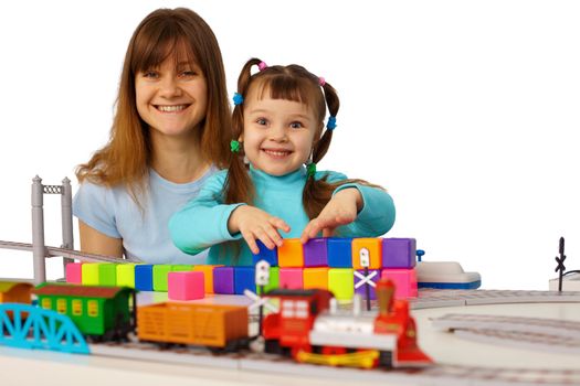 Young mother and daughter playing with toys isolated on white background