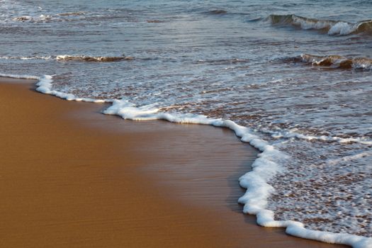 Wave surging on sand on beach