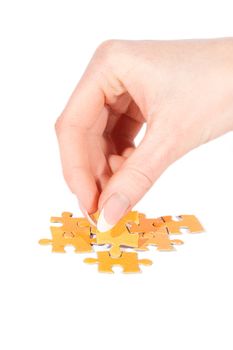 Woman hand putting right piece in puzzle over white
