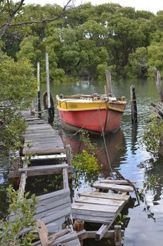 Old broken jetty and boat at Moreton Bay in south east Queensland, Australia.