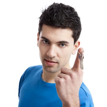 Portrait of a handsome young man holding the keys of your home, focus is on the keys