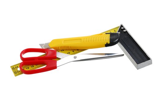 Set of cutting tools including scissors, utility knife and carpenter square isolated on white background