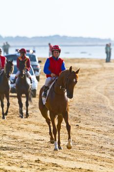 SANLUCAR DE BARRAMEDA, CADIZ, SPAIN - AUGUST 10: Unidentified riders at the start of race horses on Sanlucar de Barrameda beach on August 10, 2011 in Sanlucar de Barrameda, Cadiz, Spain.