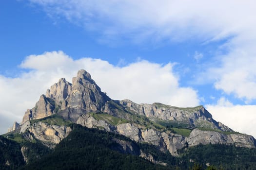 Sunny mountain and big cloud upon it by beautiful weather