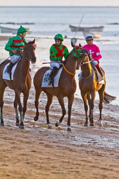 SANLUCAR DE BARRAMEDA, CADIZ, SPAIN - AUGUST 10: Unidentified riders at the start of race horses on Sanlucar de Barrameda beach on August 10, 2011 in Sanlucar de Barrameda, Cadiz, Spain.