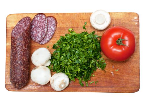 Some ingredients for pizza: parsley, sasuage, tomatoes.