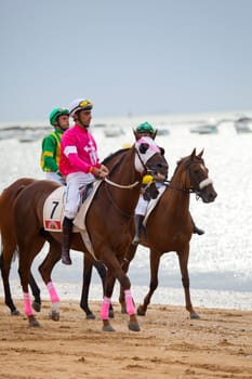 SANLUCAR DE BARRAMEDA, CADIZ, SPAIN - AUGUST 07: Unidentified riders at the start of race horses on Sanlucar de Barrameda beach on  August 07, 2010 in Sanlucar de Barrameda, Cadiz, Spain.