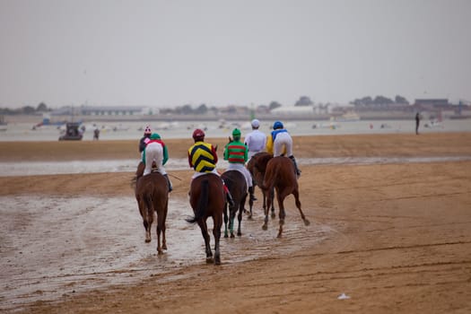 SANLUCAR DE BARRAMEDA, CADIZ, SPAIN - AUGUST 07: Unidentified riders at the start of race horses on Sanlucar de Barrameda beach on  August 07, 2010 in Sanlucar de Barrameda, Cadiz, Spain.