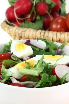 a white bowl of fresh mixed salad