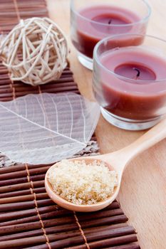 Salt in wooden spoon and other spa products with candles