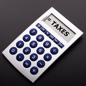 tax or taxes concept with business calculator and word