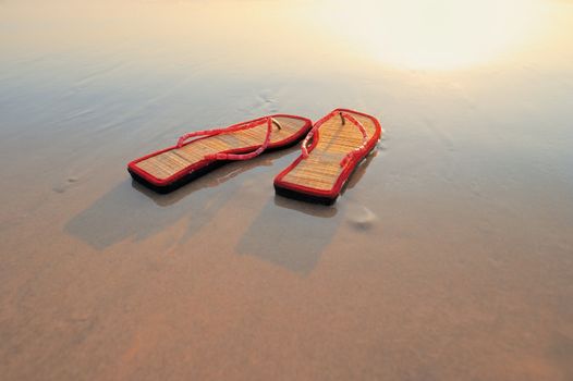 Beach sandals on the sandy sea coast