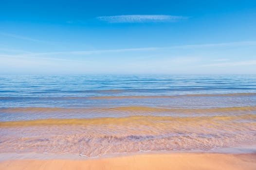 Sand beach with waves at the sea