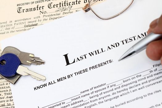 Last Will And Testament document studied with keys and certificate of title.
