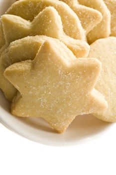 Star shaped homemade cookies in a white plate on white background