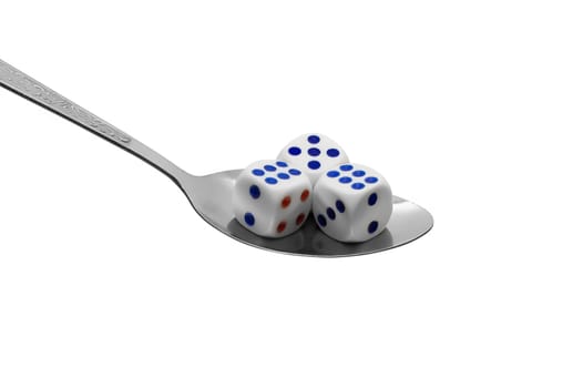 Metal spoon with dices on white background