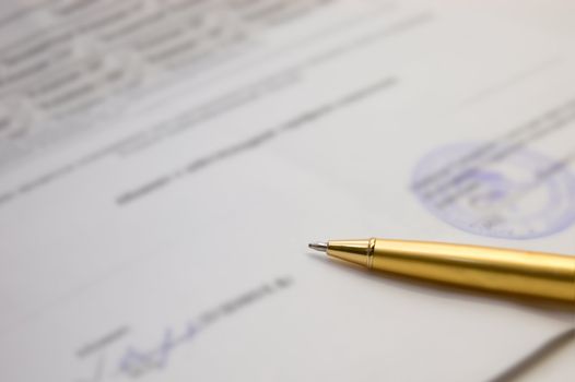 A golden pen on a contract