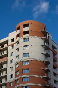 Modern multistory house of red and white bricks on  blue sky background