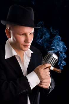 Jazzman and retro microphone in suit and hat