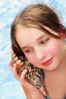 Portrait of a teenage girl with large tropical seashell