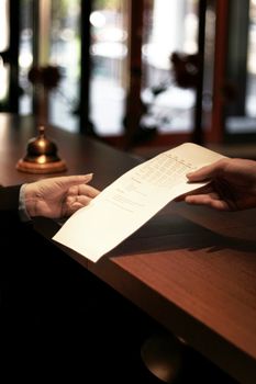 female hotel manager recieves accommodation reservation, selective focus on hand