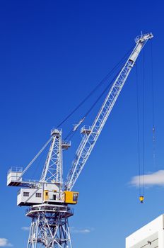 High crane under a blue sky in a shipyard