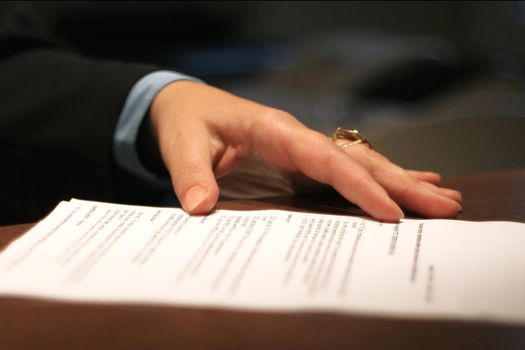 female manager hand on contract before signing it, selective focus on hand