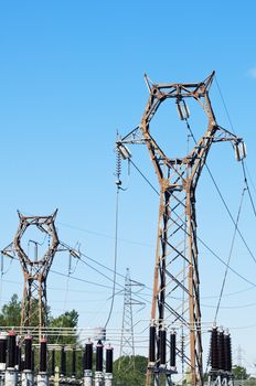 High voltage pylons against blue sky