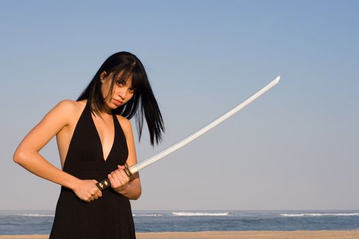 Asian model posing with a sword against blue sky